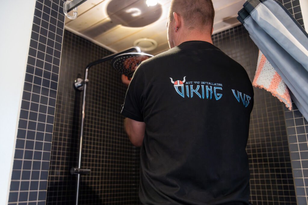 VVS-installatør reparerer bruser i badeværelse