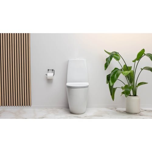 Moderne toilet på lyst badeværelse med plante